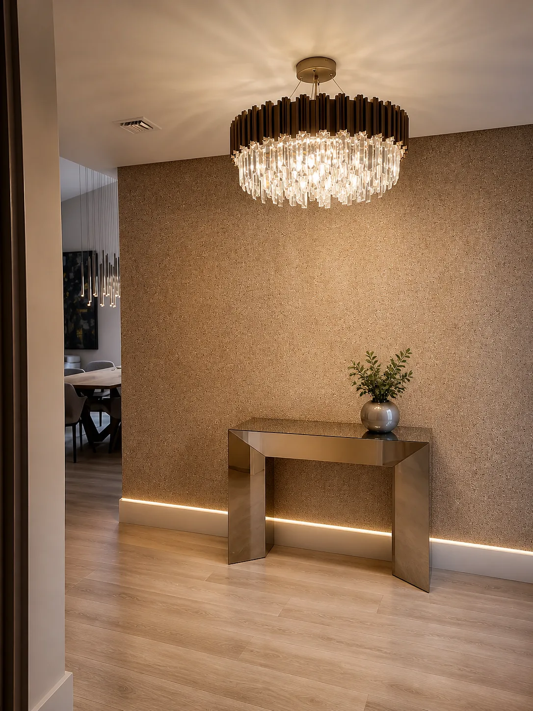 Textured wallcovering installed in an entry hall beneath a crystal chandelier, with a console table